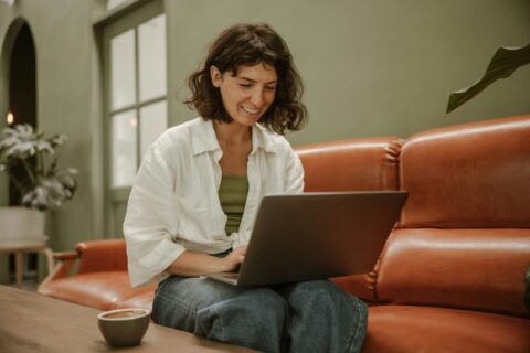 Een vrouw met een laptop op schoot.