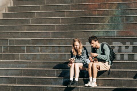 Twee jongeren zitten op een trap